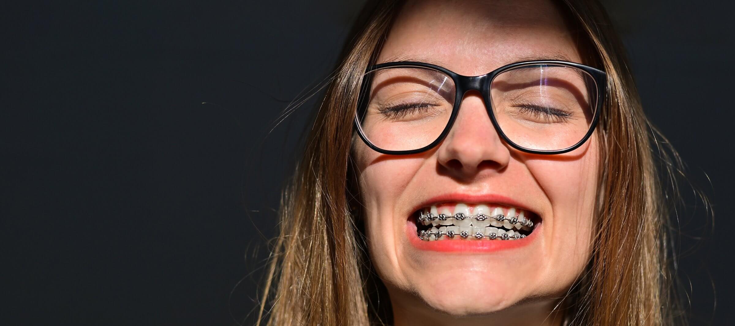 Adult orthodontic patient smiling as she schedules her next orthodontic check-up over the phone.