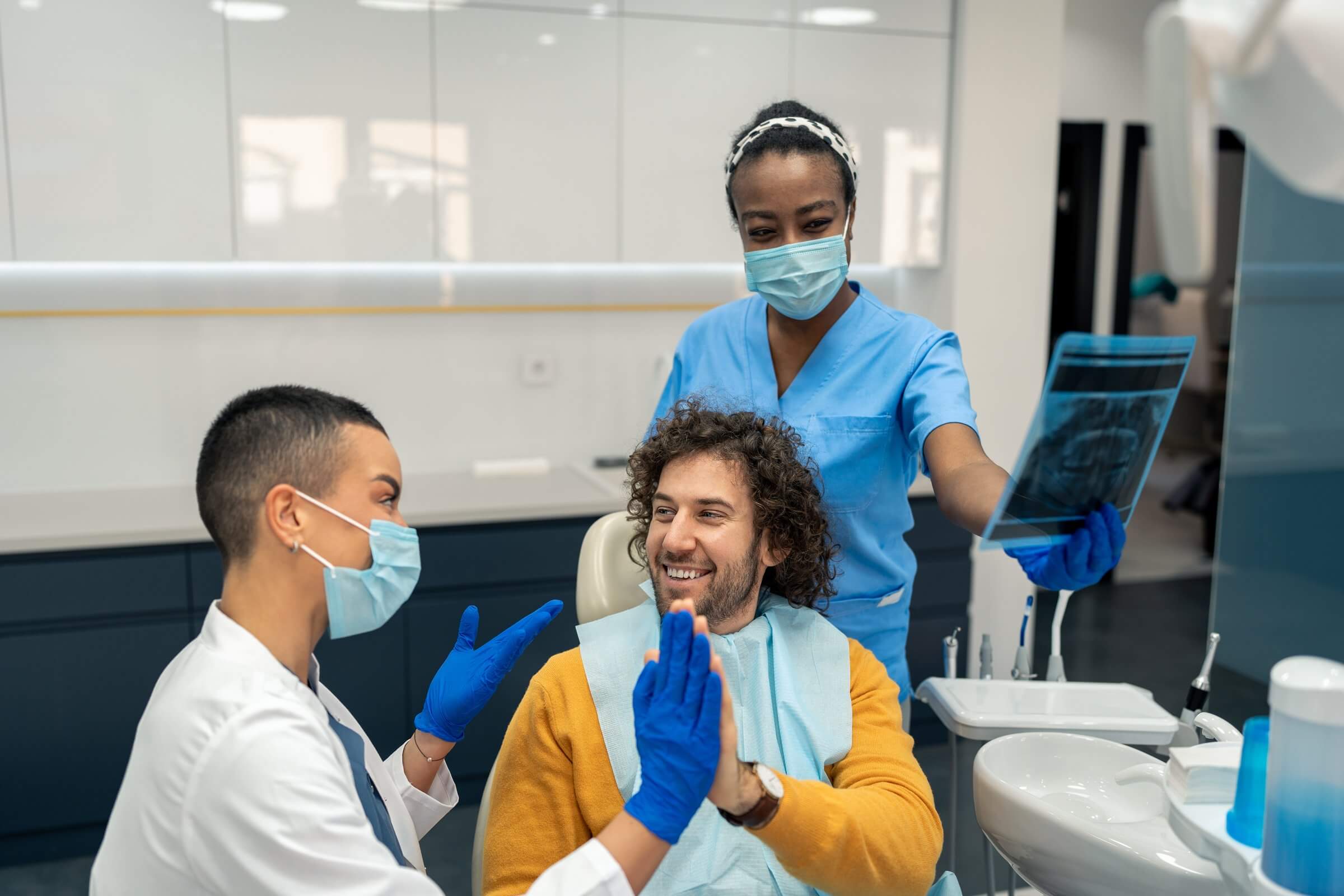 Hygienist celebrating with a patient by giving a high-five after a clean exam.