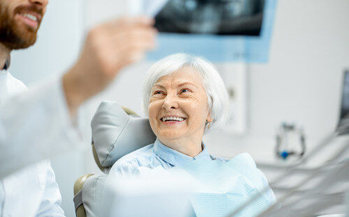 Elderly patient speaking with dentist in the practice