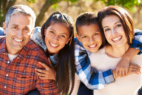 happy family of four hugging