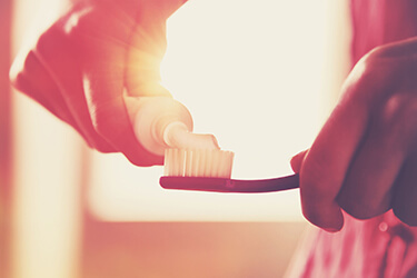 Man applying toothpaste to his toothbrush because healthy smiles are a combination of your and our efforts