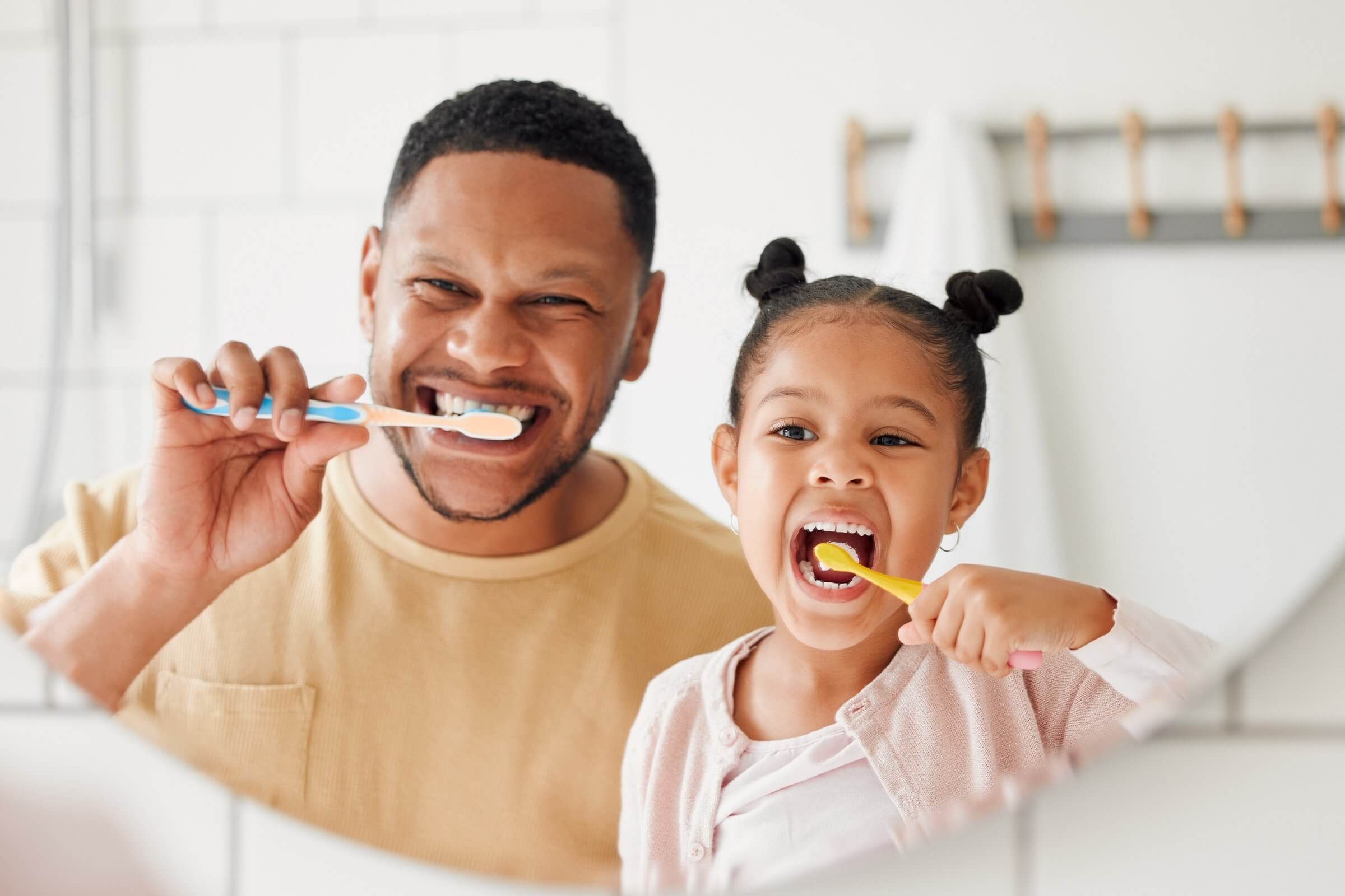 Father and daughter brushing teeth